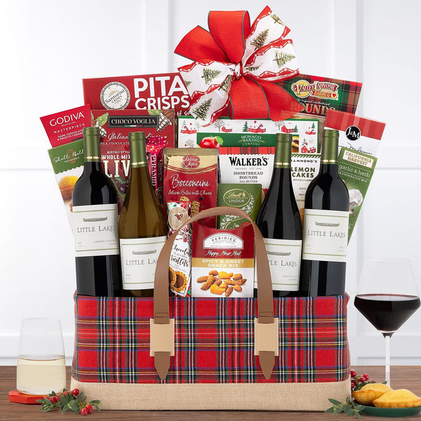 Holiday wine gift basket with four bottles of wine, Godiva chocolates, Lindt truffles, cookies, crackers, and gourmet treats
