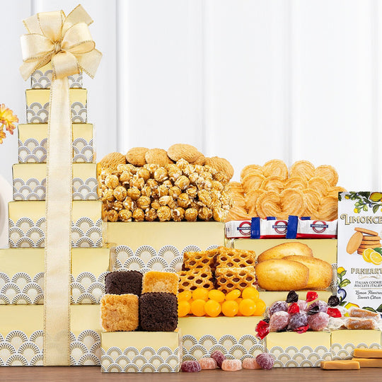 Seven-tier gift tower with decorated boxes containing brownies, cookies, caramels, fudge, candies, and caramel popcorn, tied